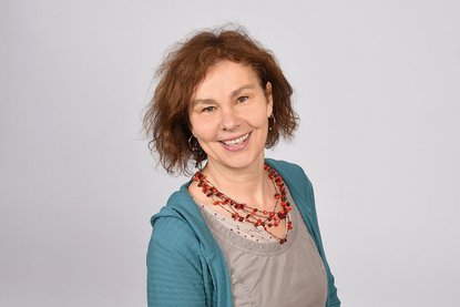 Eine Frau mit roter Kette und türkiser Jacke lächelt in die Kamera - Copyright: Fachdienst Ev. Kindertagesstätten